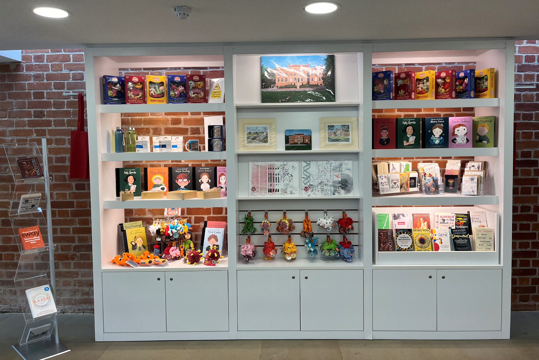 The shop in Hinxton Hall Conference Centre Reception. White units with red brick background.