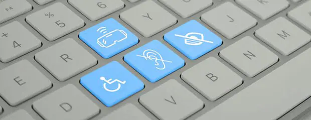 Close up of white computer keyboard showing different icons for virtual reality and accessibility.