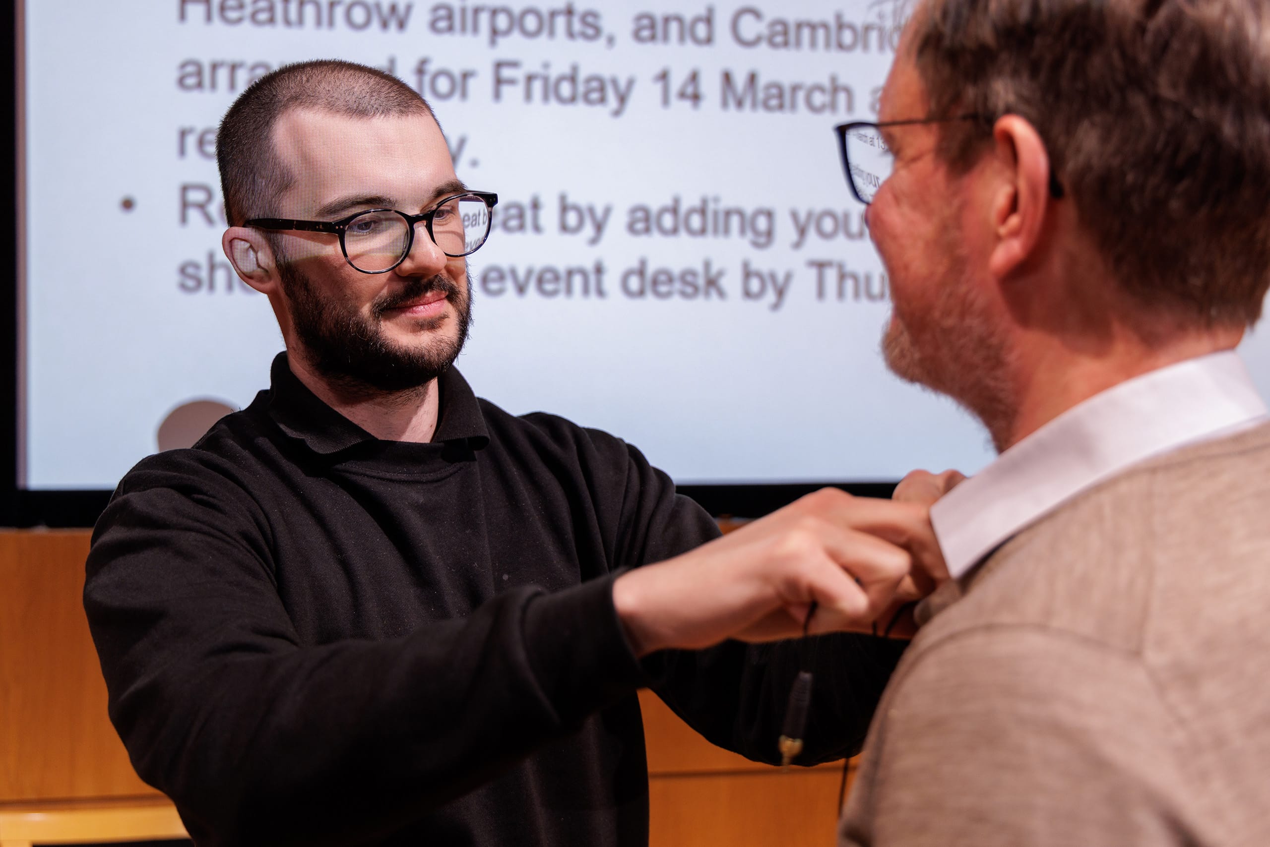 AV technician attaching a lapel mic to a speaker